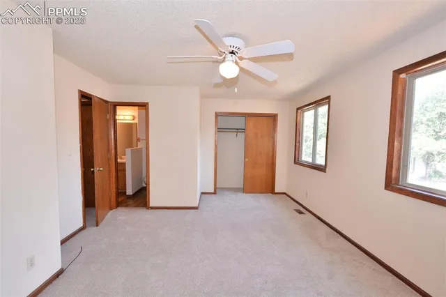 a view of an empty room with window and closet area