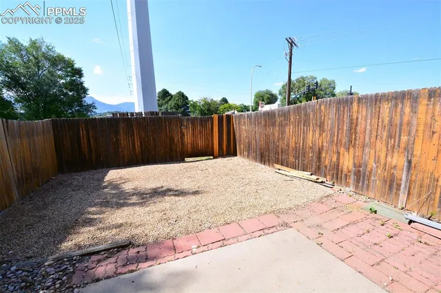 a view of a house with a wooden fence