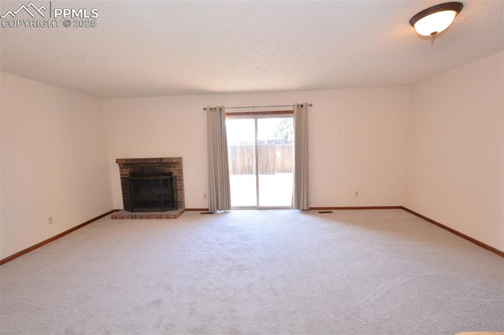 1021 Dublin Boulevard Colorado Springs, CO 80918 - Photo 7 of 20 an empty room with a fireplace and a window