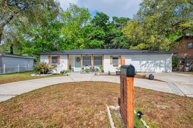 a front view of house with yard and trees in the background