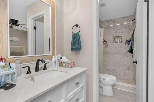 a bathroom with a sink vanity mirror and toilet