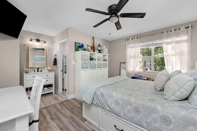 a bedroom with a bed a window and a flat screen television