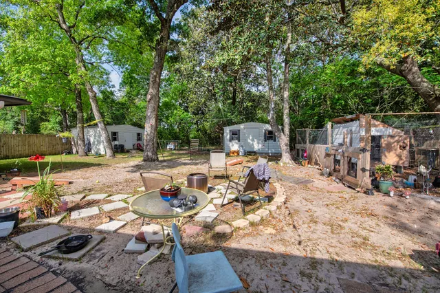 a view of backyard of a house with table and chairs