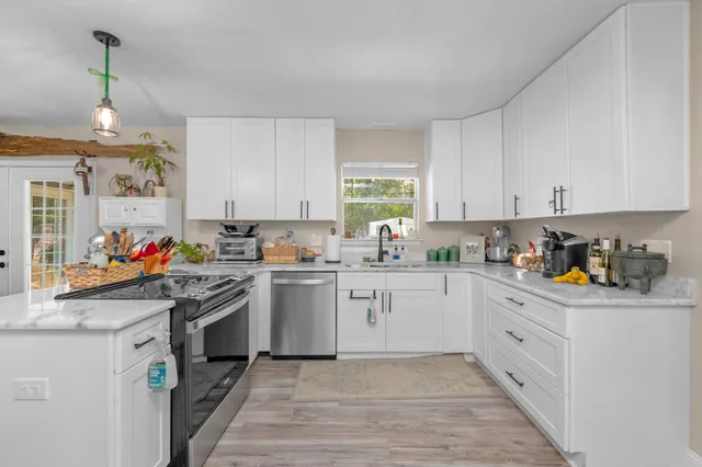 a kitchen with granite countertop white cabinets and white appliances