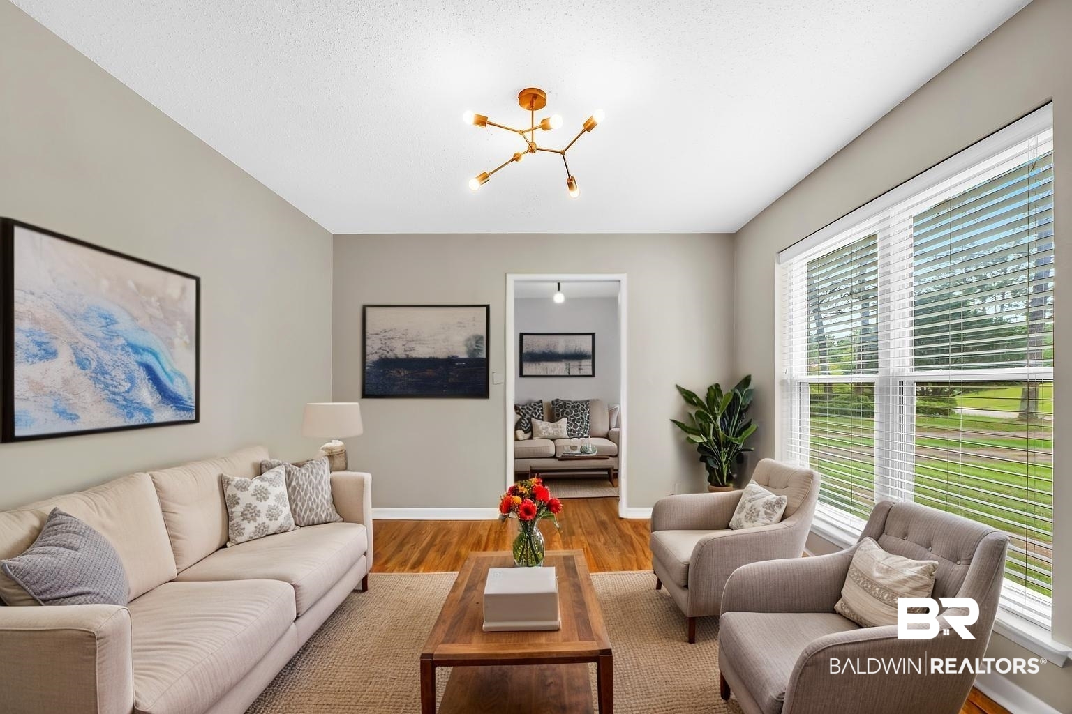 28 Caisson Trace Spanish Fort, AL 36527 - Photo 6 of 51 Living area featuring a wealth of natural light, baseboards, wood finished floors, and an inviting chandelier