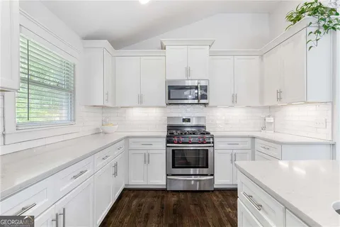 a kitchen with stainless steel appliances a white stove top oven and a sink