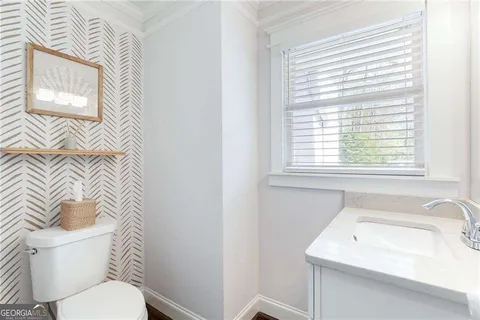 a bathroom with a sink a toilet and a window