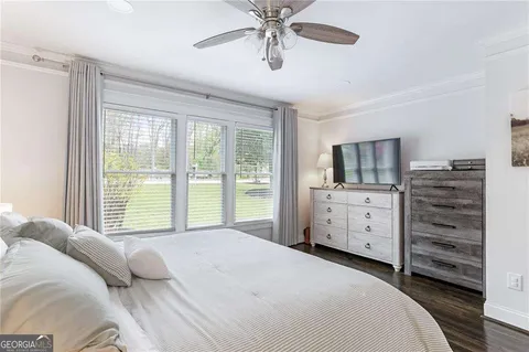 a bedroom with a bed dresser and a flat tv screen