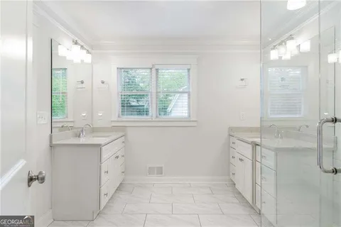 a spacious bathroom with double vanity and a mirror