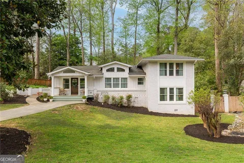 a front view of a house with a garden and trees
