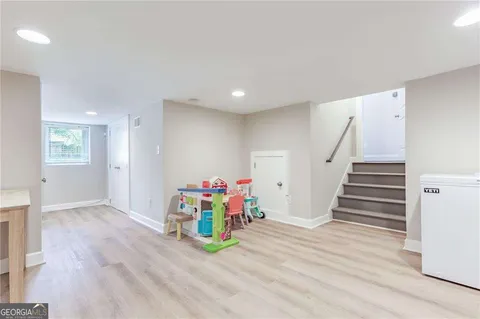 a view of a hallway with wooden floor and stairs