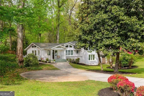 a front view of a house with a yard and trees