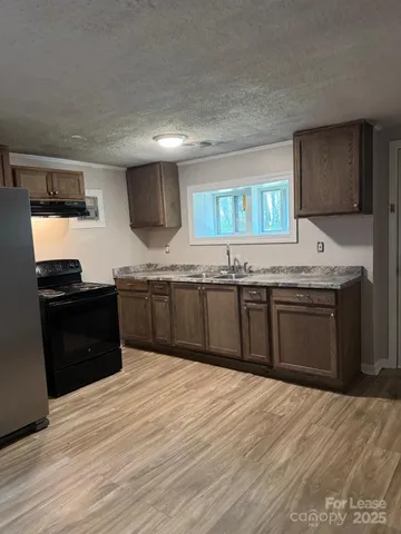 a kitchen with granite countertop a sink and a stove top oven