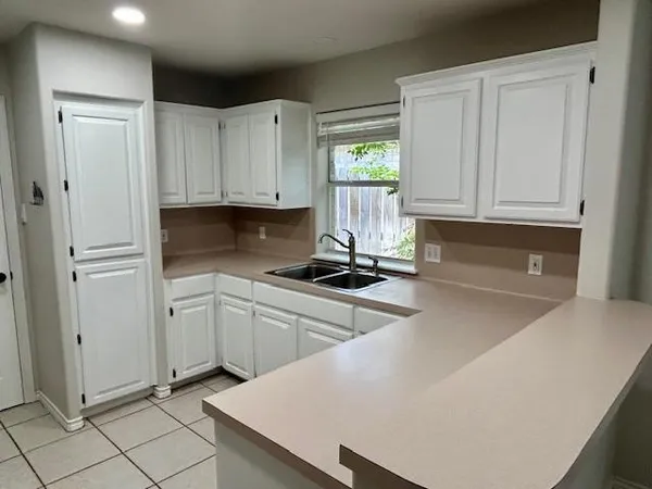 a kitchen with stainless steel appliances granite countertop a refrigerator sink and white cabinets