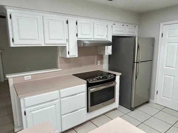 a kitchen with white cabinets and stainless steel appliances