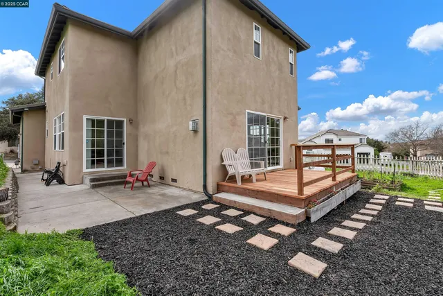 a view of a house with backyard and sitting area