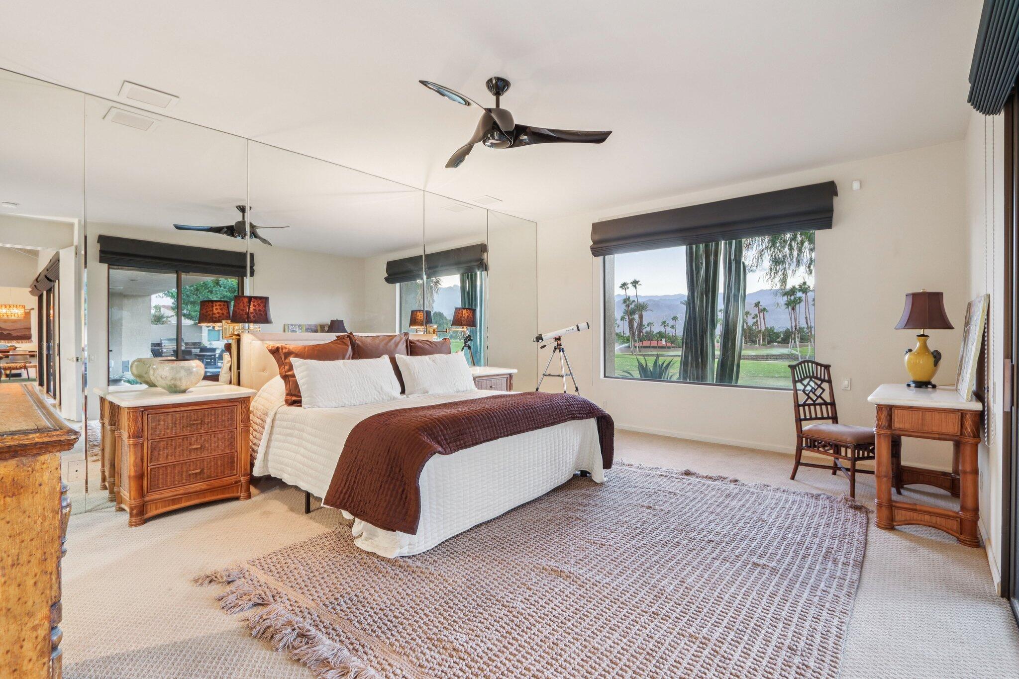 829 Inverness Drive Rancho Mirage, CA 92270 - Photo 13 of 27 a spacious bedroom with a large bed and a chandelier