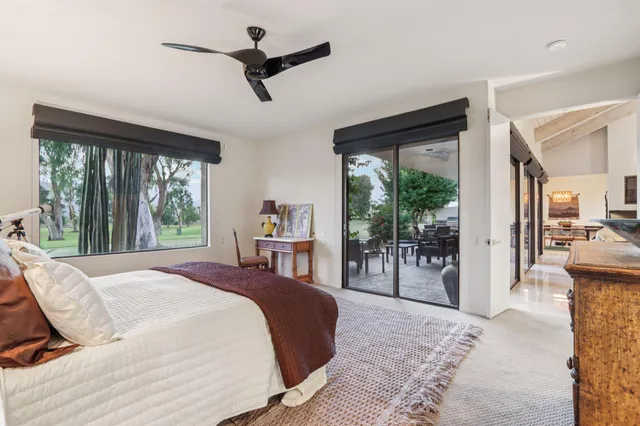 a bedroom with a bed a chandelier and large window