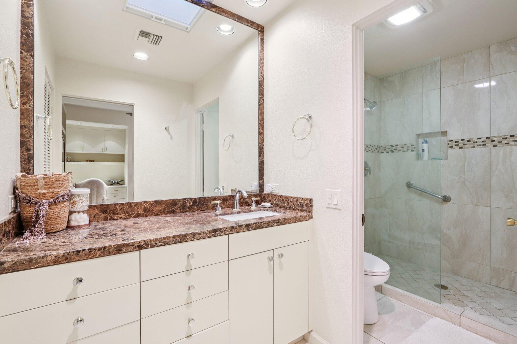 829 Inverness Drive Rancho Mirage, CA 92270 - Photo 19 of 27 a bathroom with a granite countertop sink a mirror and a shower