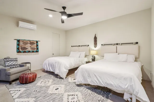 a bedroom with two beds and painting on the wall