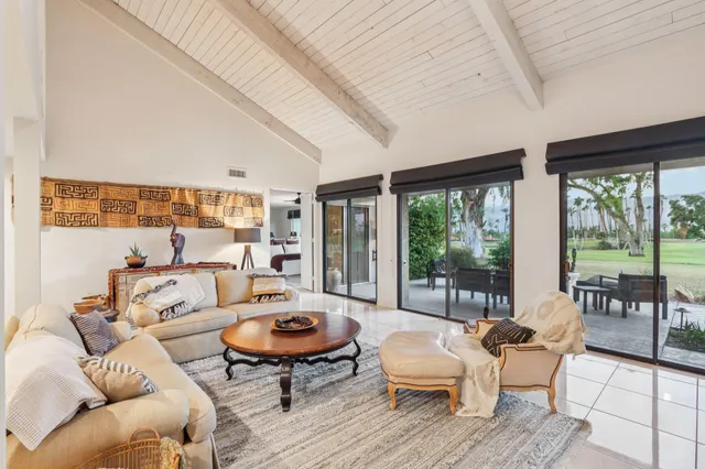 a living room with furniture and a large window with garden view
