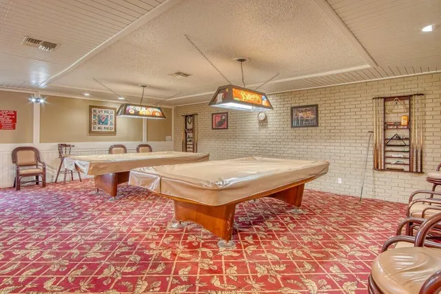 a living room with chairs a rug and kitchen view