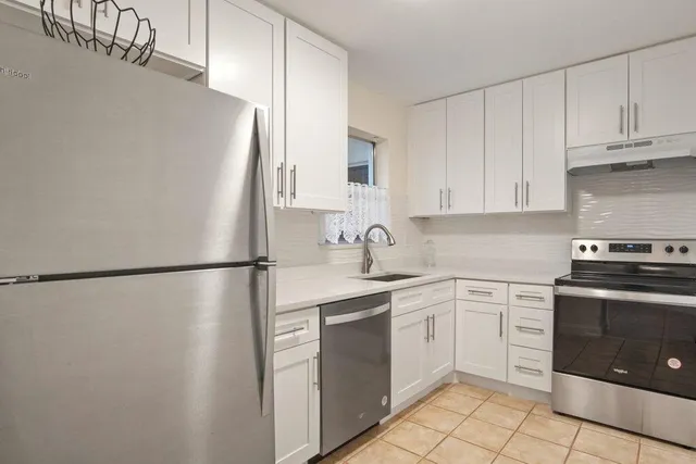 a kitchen with white cabinets and white appliances