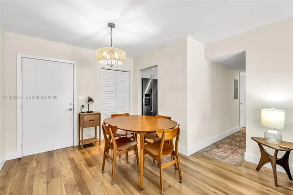 a dining room with wooden floor a chandelier a wooden table and chairs