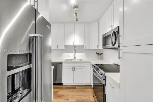 a kitchen with stainless steel appliances granite countertop a refrigerator a stove a sink and a microwave