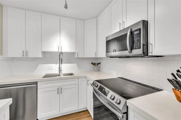 a kitchen with stainless steel appliances a stove a microwave a sink and cabinets