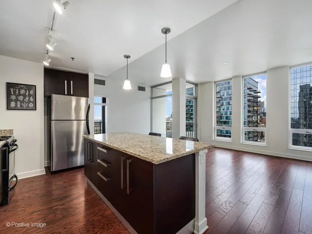 a kitchen with stainless steel appliances granite countertop a refrigerator a sink dishwasher a stove and a refrigerator with wooden floor