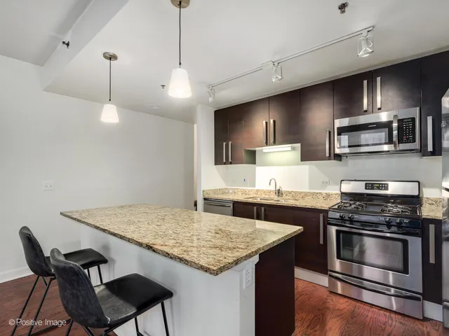 a kitchen with kitchen island a stove and a microwave