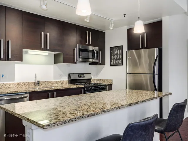 a kitchen with stainless steel appliances granite countertop a sink refrigerator and microwave