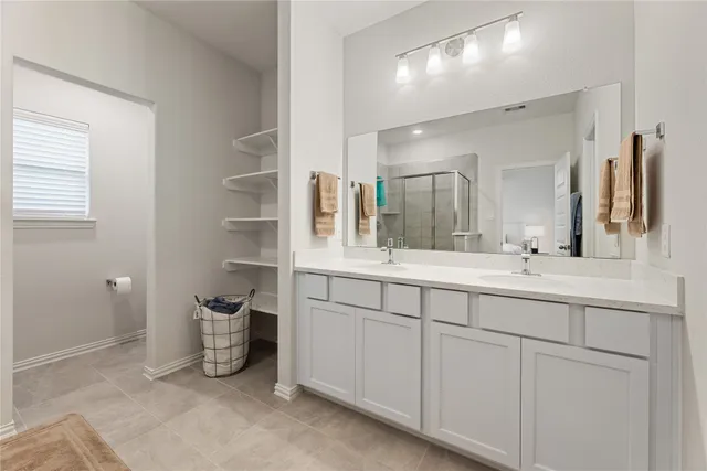 a bathroom with double vanity and a mirror