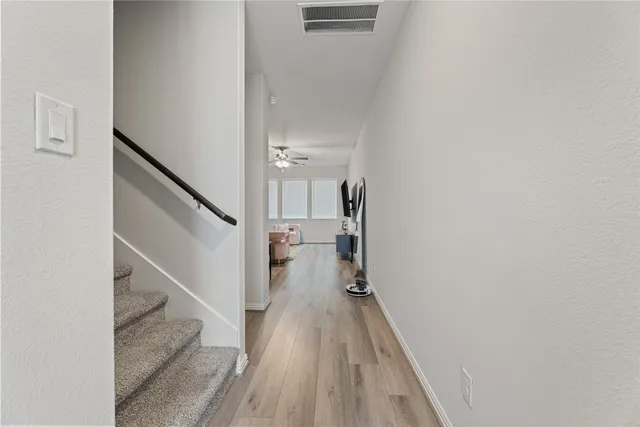 a view of a hallway with wooden floor and staircase