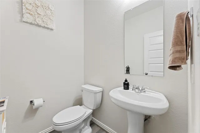 a bathroom with a sink toilet and a mirror
