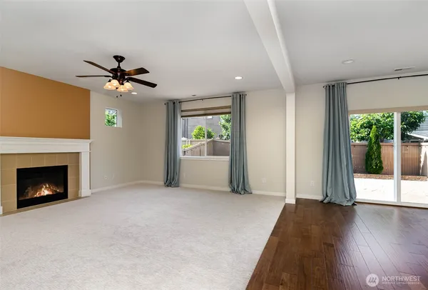 a view of an empty room with a fireplace and a window