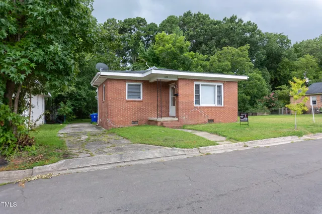a front view of a house with yard and tree s