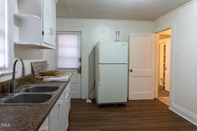 a kitchen with a refrigerator sink and cabinets