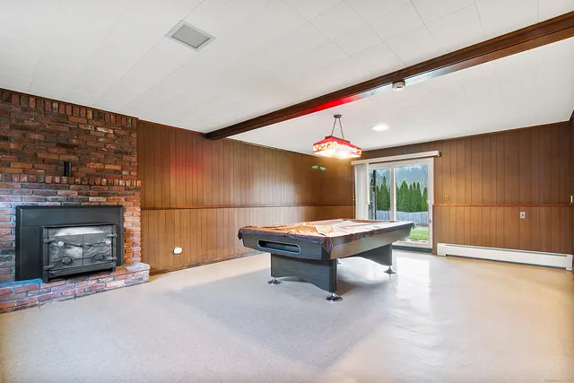 a room with pool table and a fireplace