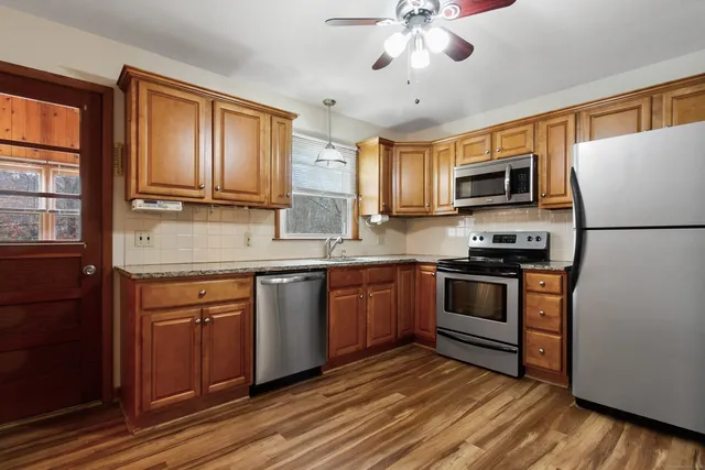 a kitchen with kitchen island granite countertop a refrigerator stove microwave and sink