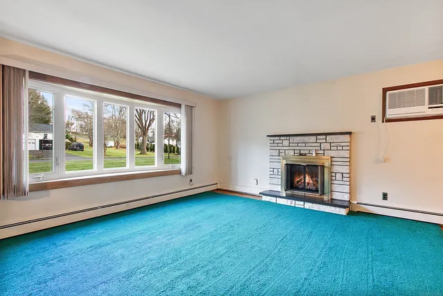 a view of empty room with wooden floor and fireplace