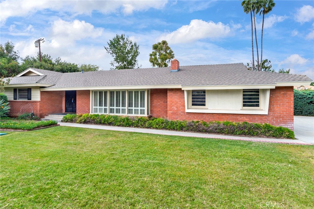 a front view of a house with a garden and yard