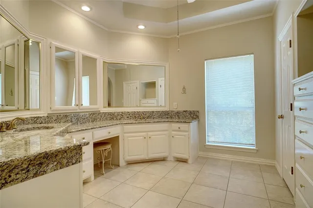 a bathroom with a granite countertop sink a mirror and a bathtub