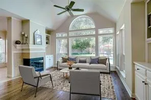 a living room with furniture large window and wooden floor