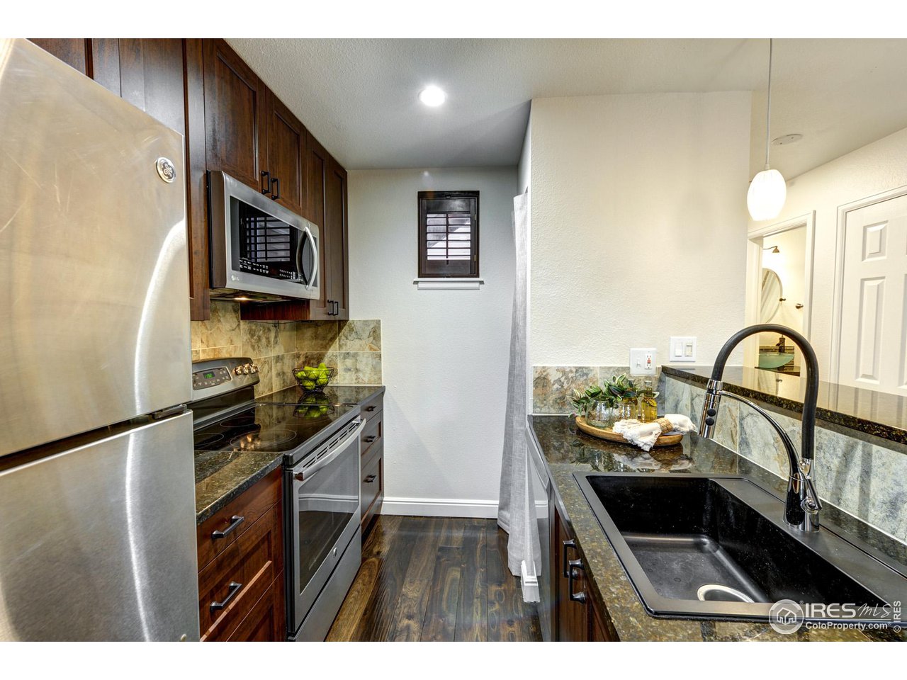 3025 Broadway, Unit 8 Boulder, CO 80304 - Photo 4 of 16 a kitchen with a sink and wooden cabinets