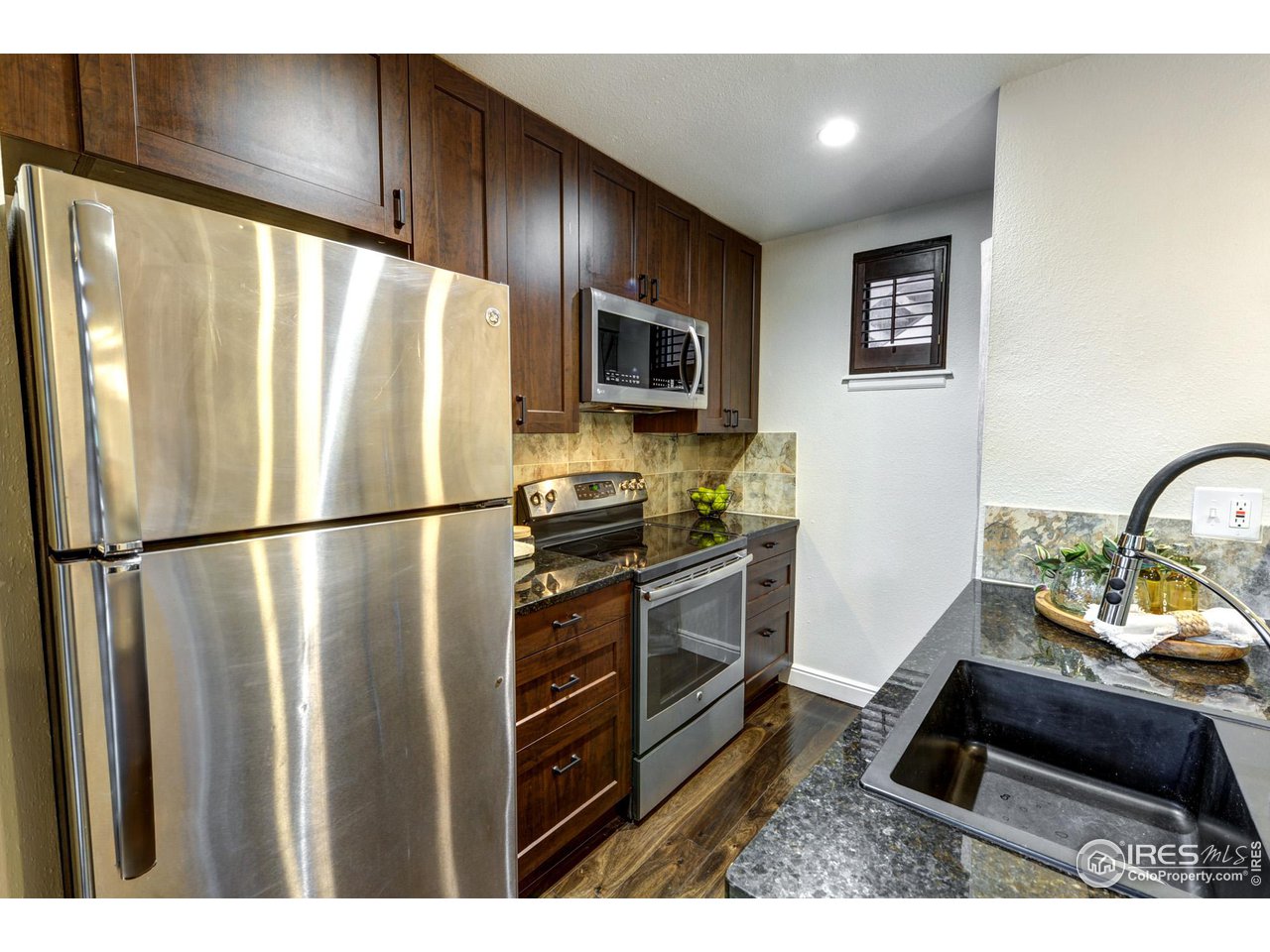 3025 Broadway, Unit 8 Boulder, CO 80304 - Photo 6 of 16 a kitchen with stainless steel appliances granite countertop a refrigerator a stove a sink and a microwave