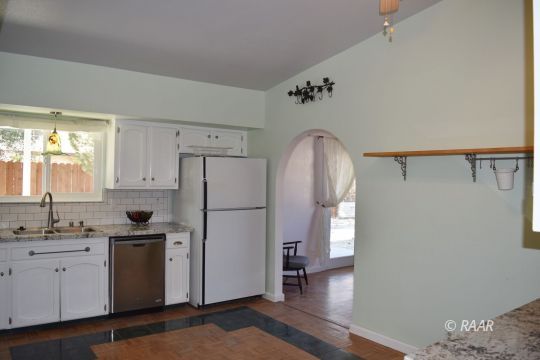 313 South Lilac Street Ridgecrest, CA 93555 - Photo 12 of 26 a kitchen with a refrigerator sink and cabinets