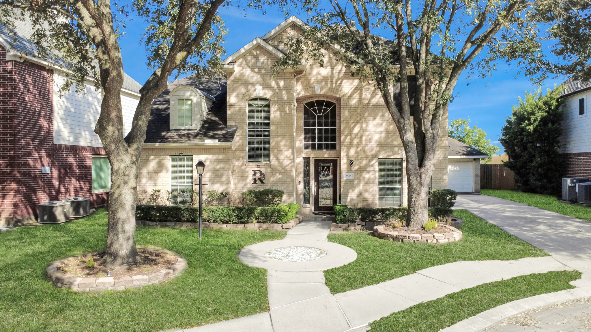 3515 Shadowside Court Houston, TX 77082 - Photo 1 of 31 a front view of a house with a garden and trees