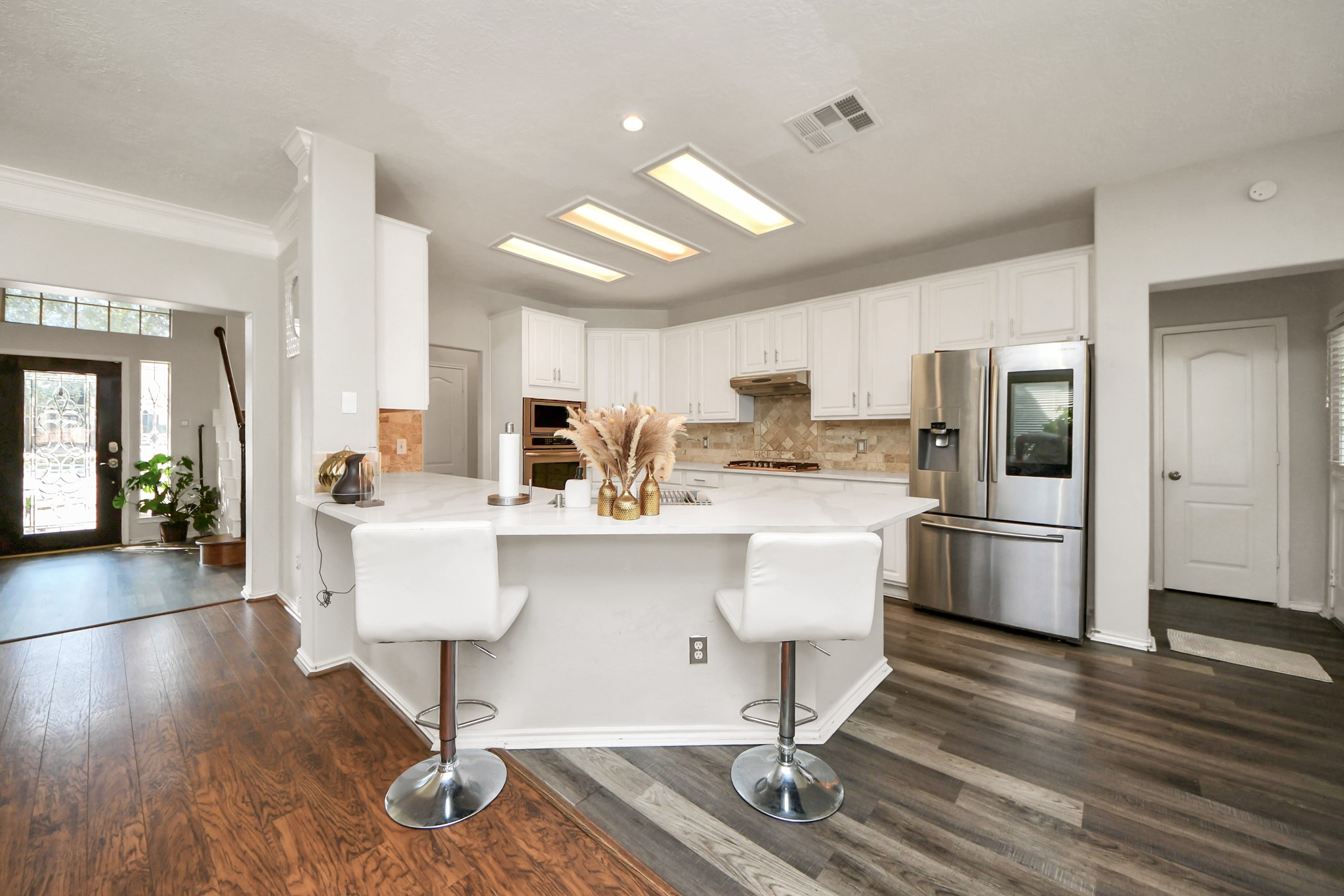 3515 Shadowside Court Houston, TX 77082 - Photo 6 of 31 a kitchen with stainless steel appliances a refrigerator a stove a sink dishwasher and white cabinets with wooden floor